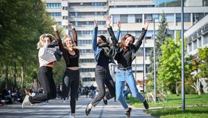 Vier Studierende am JKU Campus, die in die Luft springen