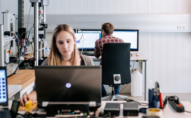 zwei Studierende, die am PC im Labor arbeiten