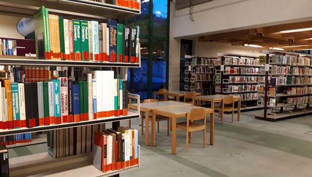 Regale mit Büchern der Fachbibliothek für Chemie inmitten des Lesebereichs der Hauptbibliothek der JKU.