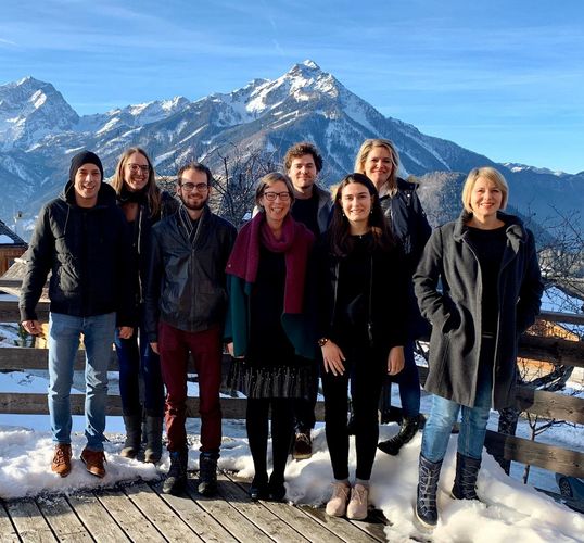 The 8 members of the Robopsychology Lab team standing in the snow and sun in front of the mountains of Vorderstoder