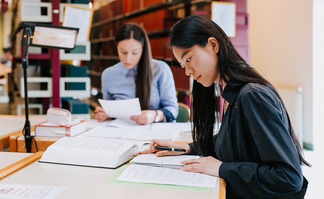 zwei lernende Studentinnen in der Bibliothek