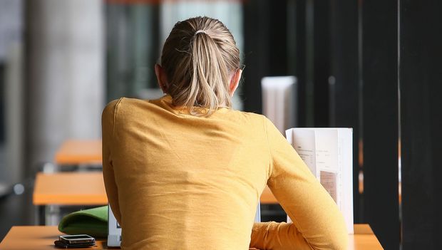 Studentin mit Notebook im Science Café sitzend, Rückenansicht