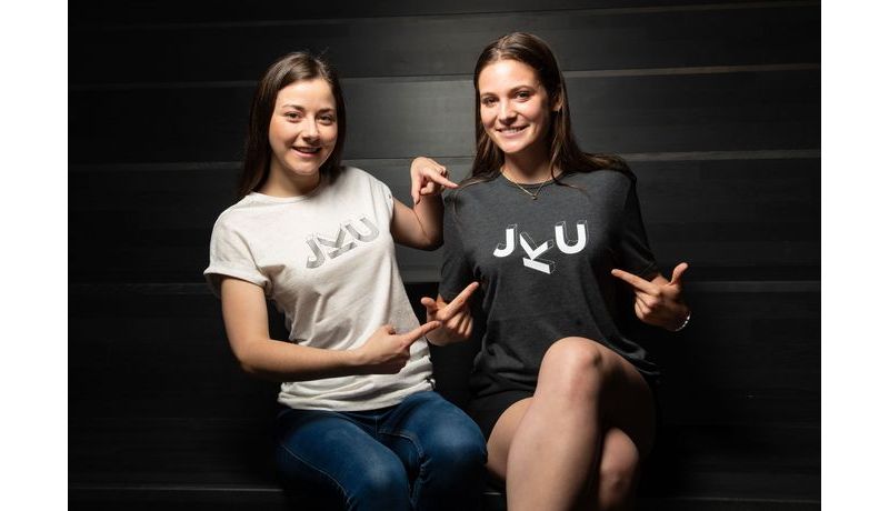 Zwei Frauen mit JKU Merchandise