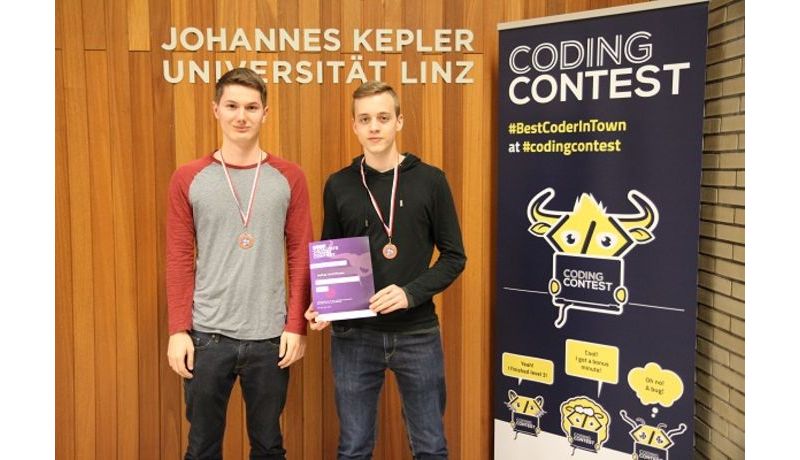 Zwei Studenten die eine Auszeichnung des Coding contest kriegen.
