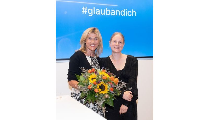 Preisträgerin Sarah Stainer erhält einen Blumenstrauß von der Sparkasse