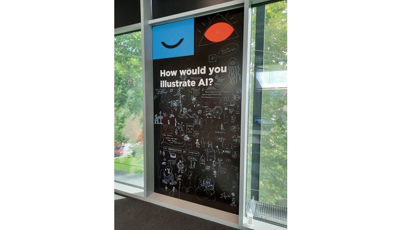 Wandtafel mit der Frage "How would you illustrate AI?" und vielen Handzeichnungen