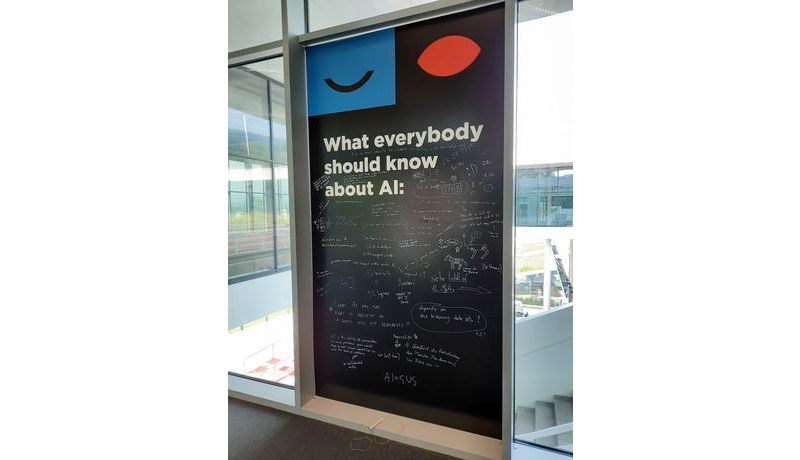 Wandtafel mit Text "What everybody should know about AI" und vielen Notizen